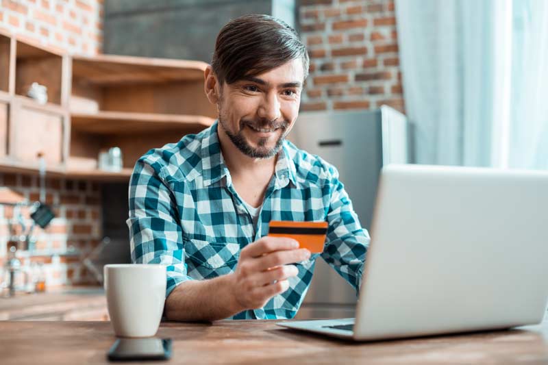 Man with gift card redeeming rewards on his computer